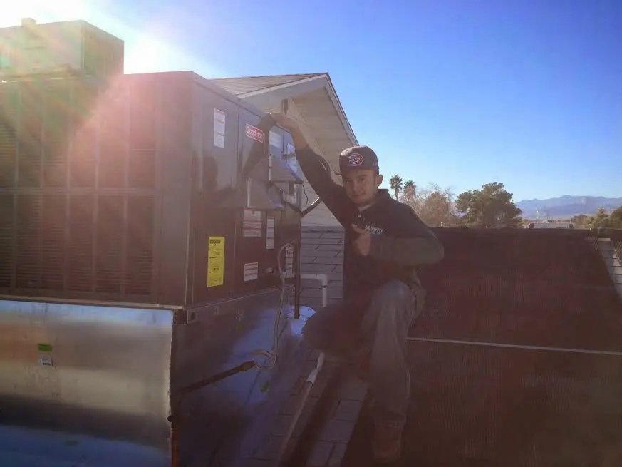 HVAC technician performing HVAC Inspection on a rooftop unit in Catoosa